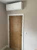 Internal air conditioning unit above door in bedroom